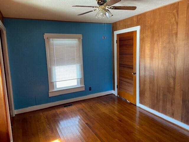 unfurnished bedroom featuring dark wood-type flooring, ceiling fan, and a closet