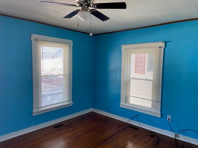 empty room with ceiling fan, a textured ceiling, and dark hardwood / wood-style flooring