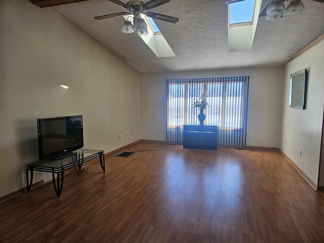 living room with lofted ceiling with skylight, dark hardwood / wood-style floors, ceiling fan, and a textured ceiling