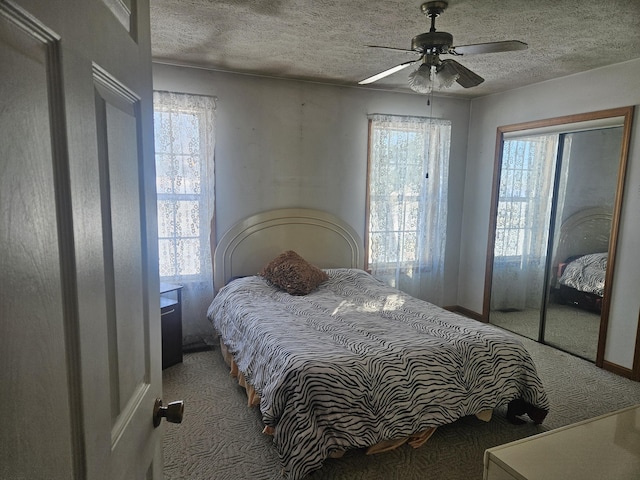 carpeted bedroom featuring multiple windows, ceiling fan, and a textured ceiling