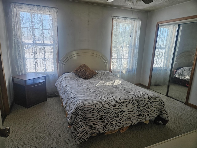 bedroom with multiple windows, light colored carpet, and a textured ceiling