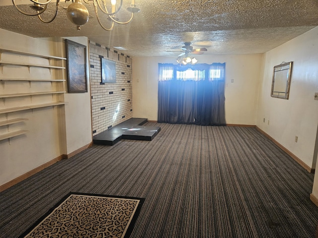 unfurnished living room featuring ceiling fan, a textured ceiling, and dark carpet