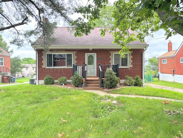 332 Swan Cir, Elsmere, KY 41018 - cape cod house featuring brick siding, a front lawn, central air condition unit, and a shingled roof