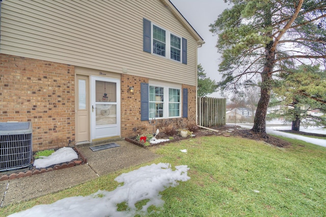 doorway to property with central AC and a yard