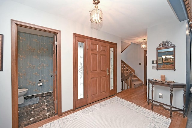 foyer entrance with hardwood / wood-style floors and a notable chandelier