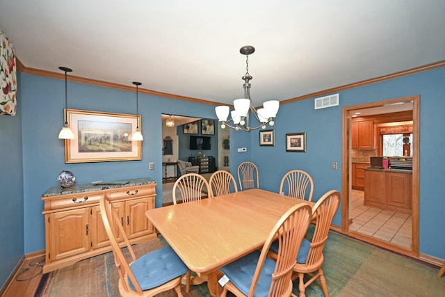 dining space with an inviting chandelier and ornamental molding