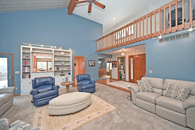 carpeted living room with ceiling fan, high vaulted ceiling, and beamed ceiling