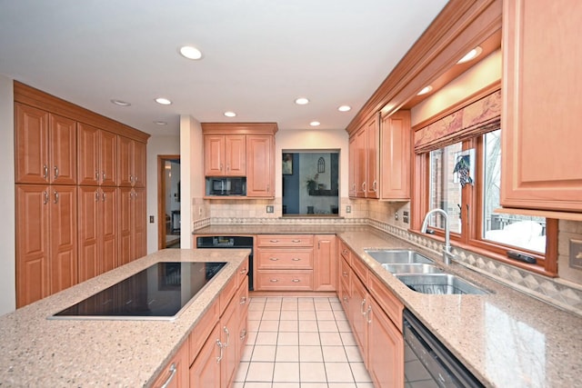 kitchen with tasteful backsplash, light stone countertops, sink, and black appliances