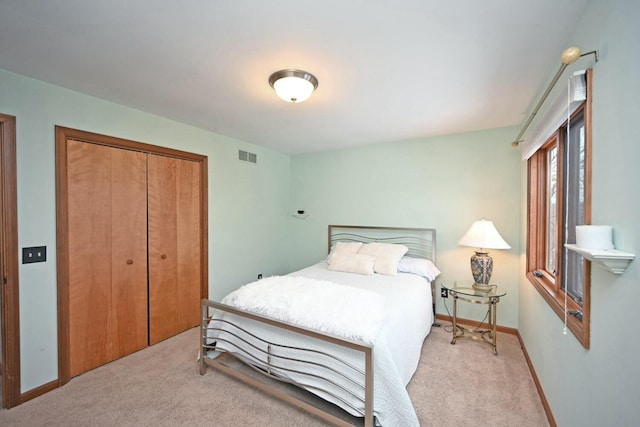 bedroom with a closet and light colored carpet