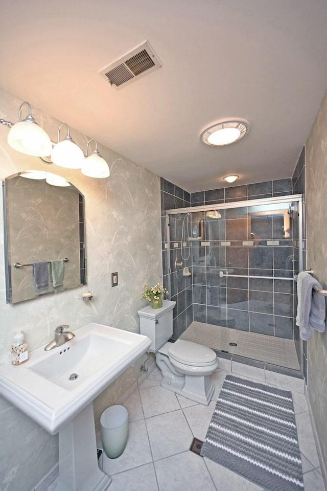 bathroom featuring sink, tile patterned floors, toilet, and walk in shower