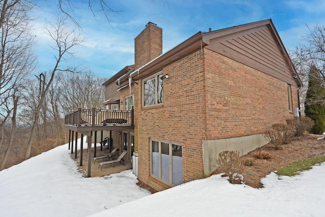 view of snowy exterior featuring a deck