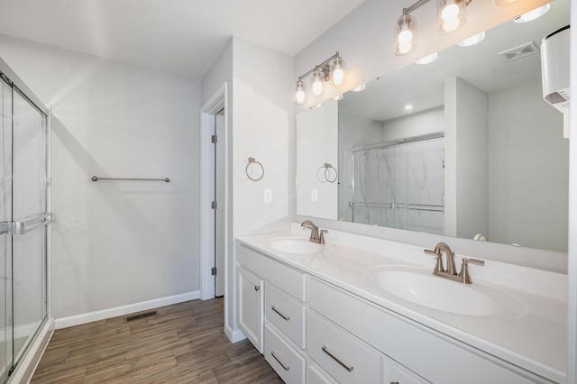 bathroom with an enclosed shower, hardwood / wood-style floors, and vanity