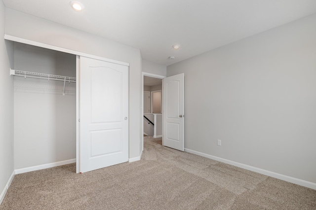 unfurnished bedroom featuring carpet flooring and a closet