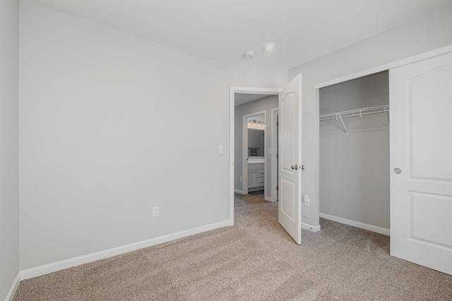 unfurnished bedroom with light colored carpet and a closet