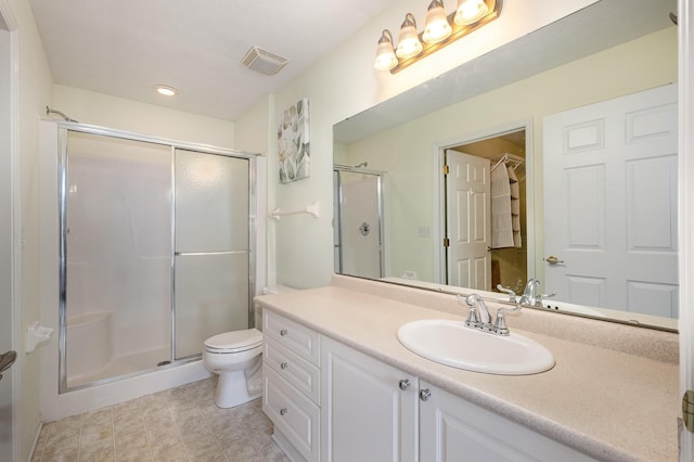 bathroom featuring vanity, toilet, and an enclosed shower