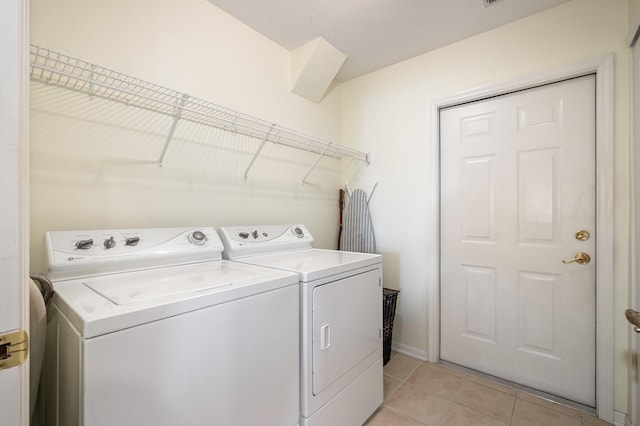 clothes washing area featuring washing machine and dryer and light tile patterned floors