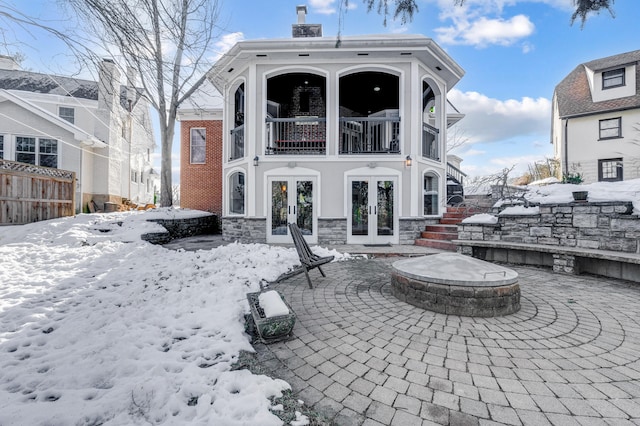 snow covered property featuring french doors