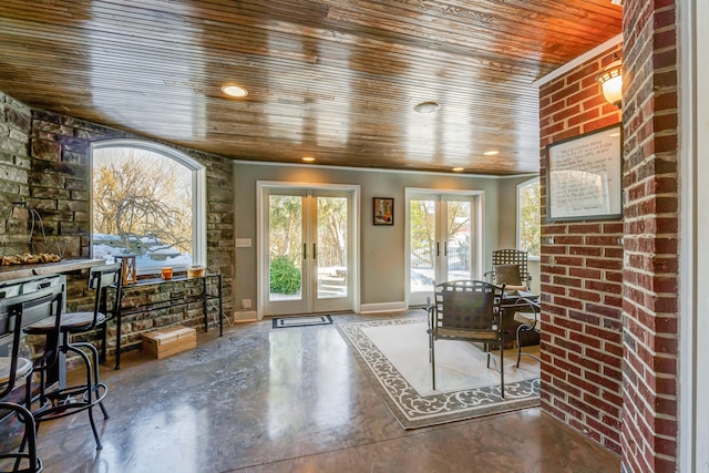 doorway with wood ceiling, brick wall, french doors, and concrete flooring