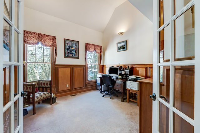 carpeted office featuring vaulted ceiling, a healthy amount of sunlight, and french doors