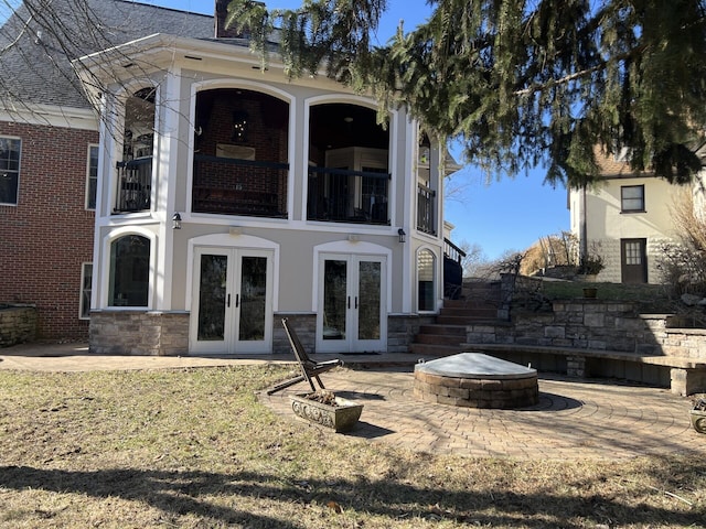 back of property featuring a fire pit, a patio area, and french doors