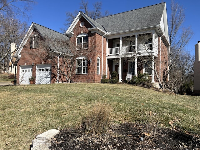 view of front property with a balcony, a garage, and a front yard