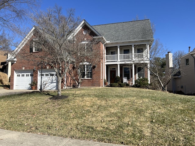 view of front of house featuring a garage, a balcony, and a front lawn