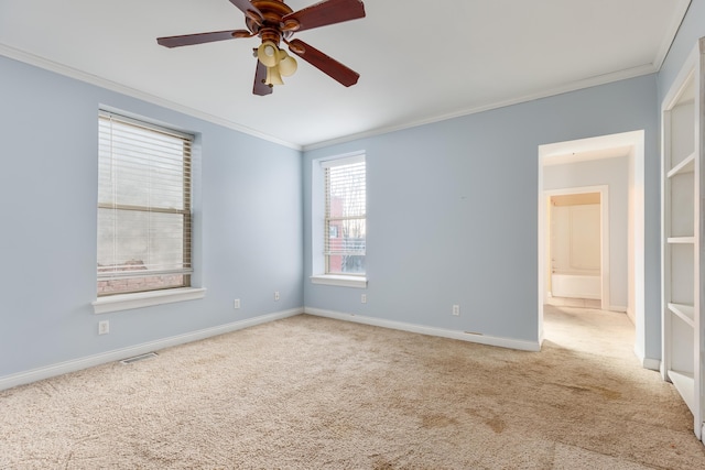 carpeted spare room featuring ceiling fan and ornamental molding