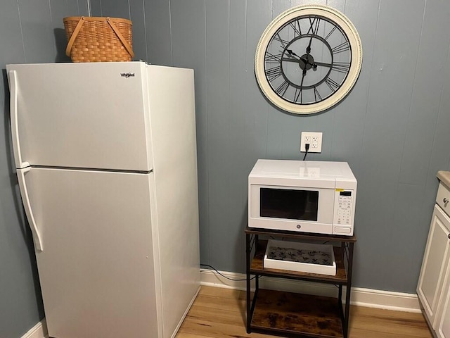 kitchen featuring white cabinetry, white appliances, and light hardwood / wood-style floors