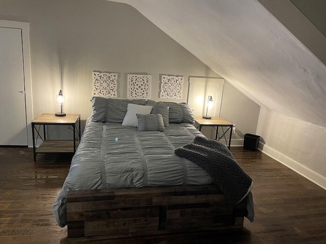 bedroom with dark wood-type flooring and vaulted ceiling