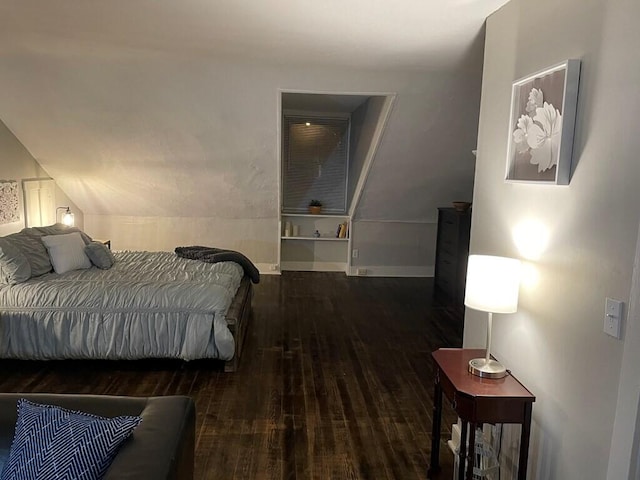 bedroom featuring dark wood-type flooring and vaulted ceiling