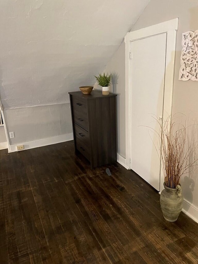 additional living space featuring lofted ceiling and dark hardwood / wood-style floors