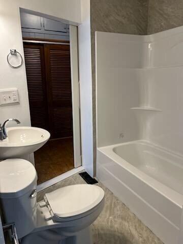 full bathroom with toilet, bathing tub / shower combination, and sink