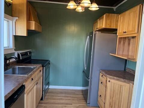 kitchen with sink, an inviting chandelier, stainless steel appliances, extractor fan, and light hardwood / wood-style floors