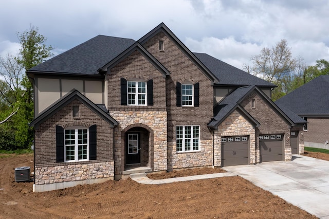 view of front of home featuring stone siding, concrete driveway, a shingled roof, an attached garage, and brick siding