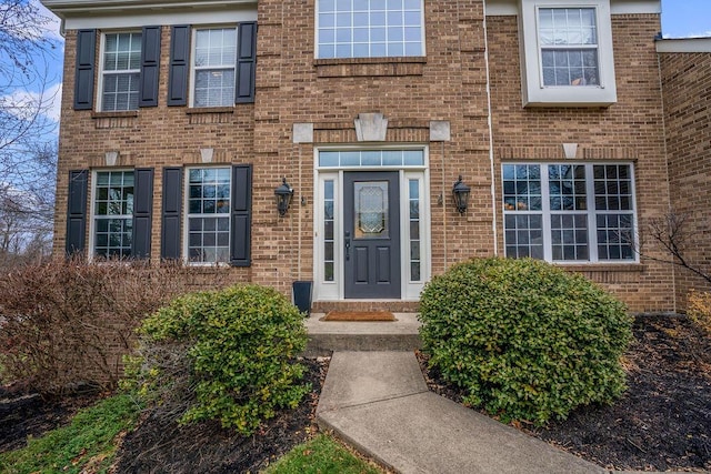 doorway to property featuring brick siding