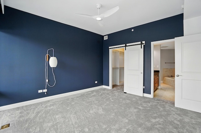 400 Riverboat Row Unit 605, Newport, KY 41071 - unfurnished bedroom featuring carpet floors, a barn door, baseboards, a closet, and ceiling fan