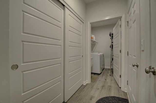 laundry area with independent washer and dryer and light hardwood / wood-style floors