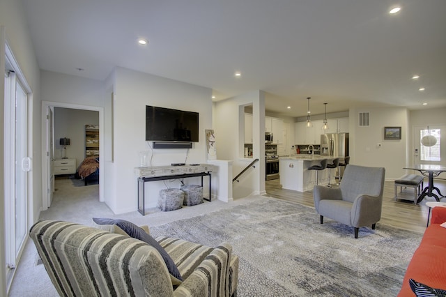 carpeted living room with sink