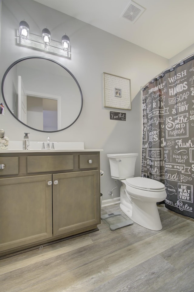 bathroom featuring vanity, toilet, and hardwood / wood-style floors