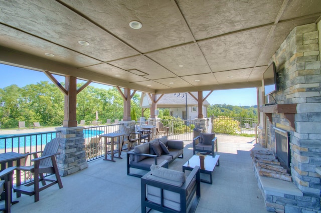 view of patio / terrace featuring a fenced in pool and an outdoor stone fireplace