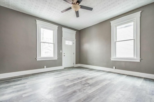 entryway with ceiling fan, a textured ceiling, and light hardwood / wood-style floors