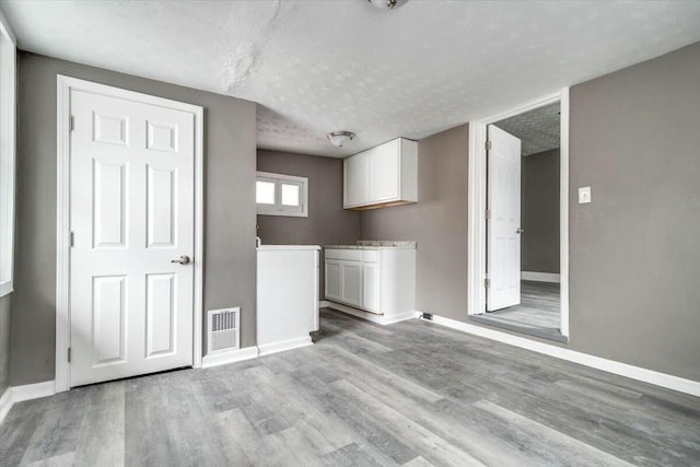 interior space with a textured ceiling and light hardwood / wood-style floors