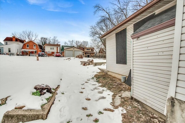 snowy yard featuring a garage