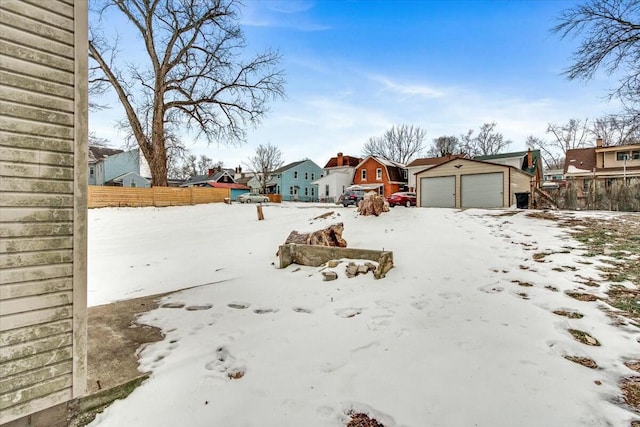 yard covered in snow with a garage and an outdoor structure