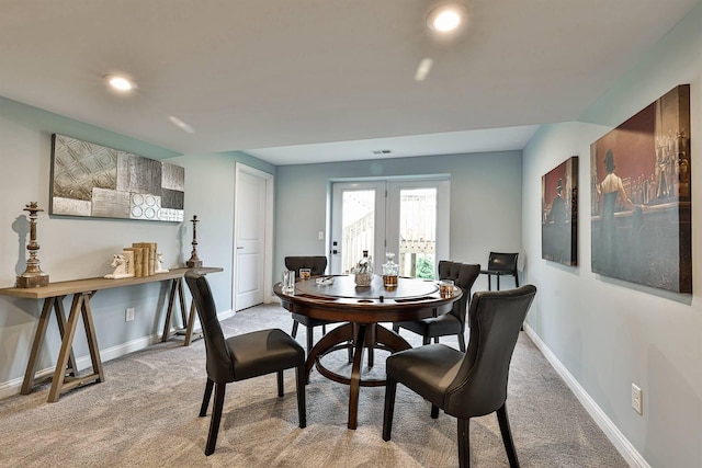 dining space with light carpet and french doors