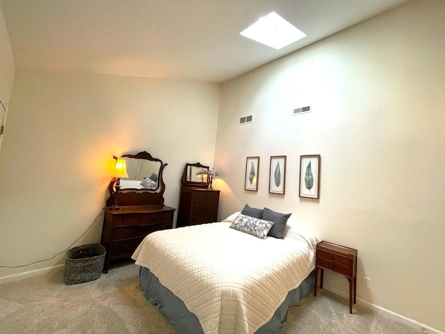 bedroom featuring a skylight and carpet