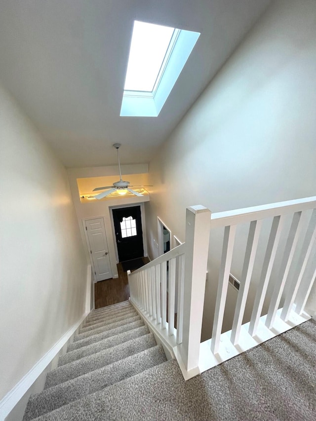 stairway with lofted ceiling, carpet floors, and ceiling fan