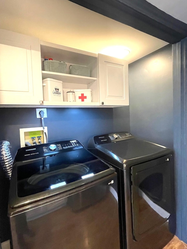 laundry area with washing machine and dryer and cabinets