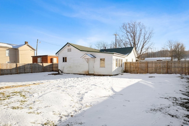 view of snow covered rear of property