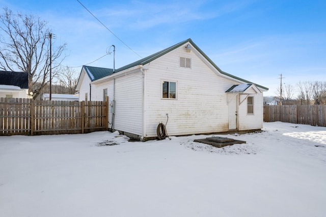 view of snow covered back of property